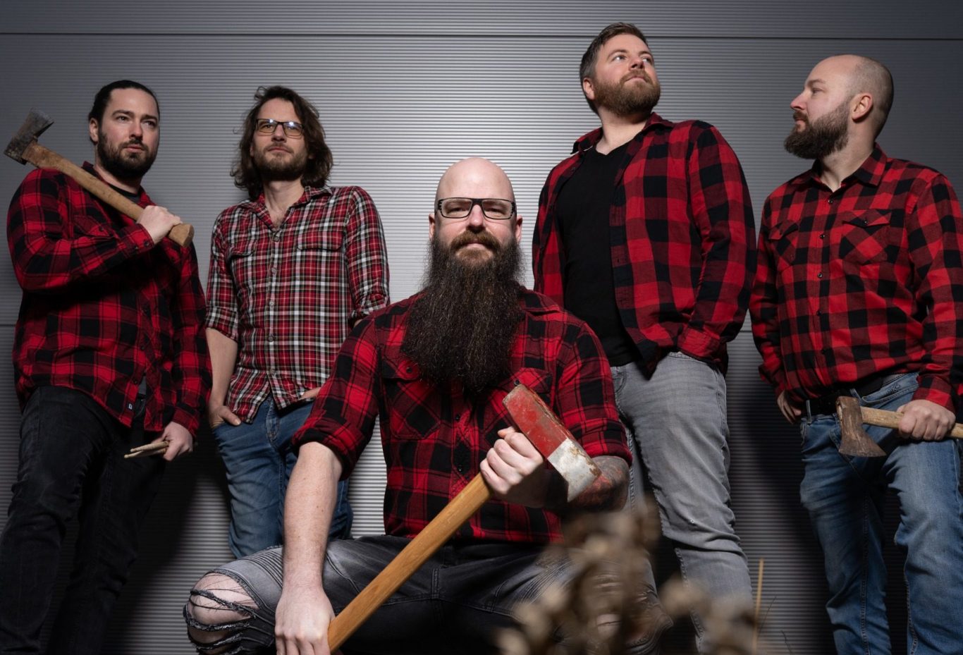 Fünf Männer in karierten Hemden pose mit Äxten in einer urbanen Umgebung. Andi Chris Sven Andi Stefan